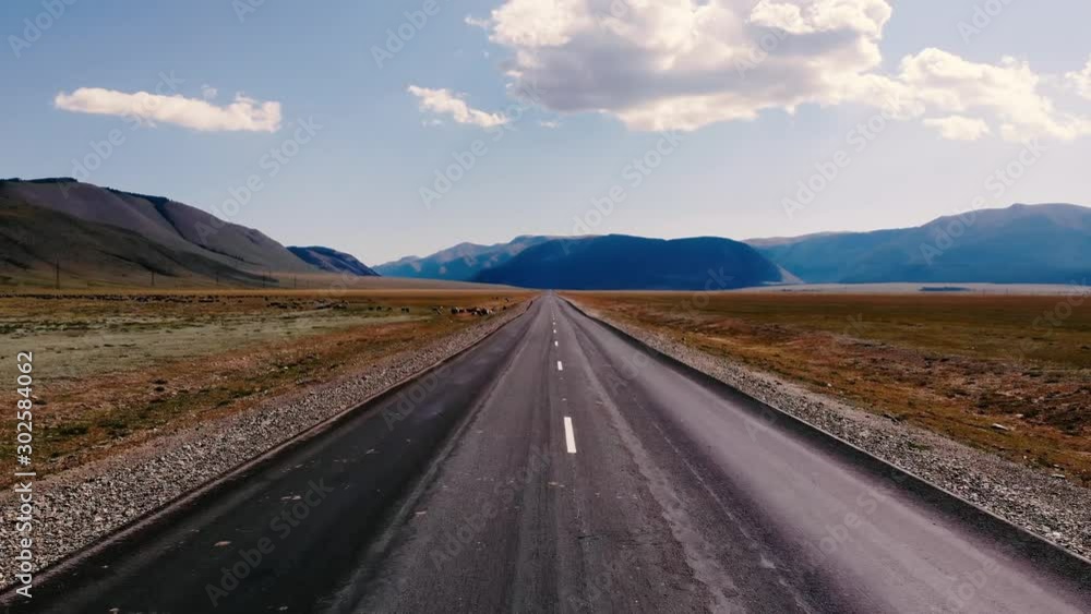 Aerial view of an empty road among the valley on a background of mountains Aerial view of an empty road among the valley on a background of mountains