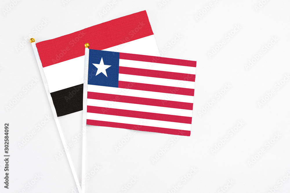 Liberia and Egypt stick flags on white background. High quality fabric, miniature national flag. Peaceful global concept.White floor for copy space. Liberia and Egypt stick flags on white background. High quality fabric, miniature national flag. Peaceful global concept.White floor for copy space.
