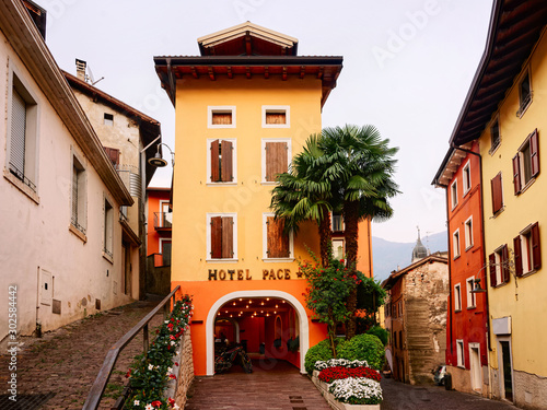 Fototapeta Naklejka Na Ścianę i Meble -  Cityscape with hotel building at Arco town center near Garda lake of Trentino of Italy. Street with house architecture at Old city in Trento near Riva del Garda. Travel and tourism. Evening