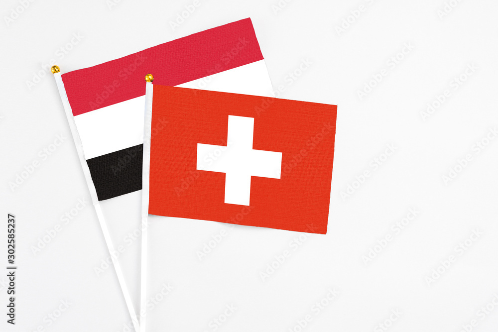 Switzerland and Egypt stick flags on white background. High quality fabric, miniature national flag. Peaceful global concept.White floor for copy space.