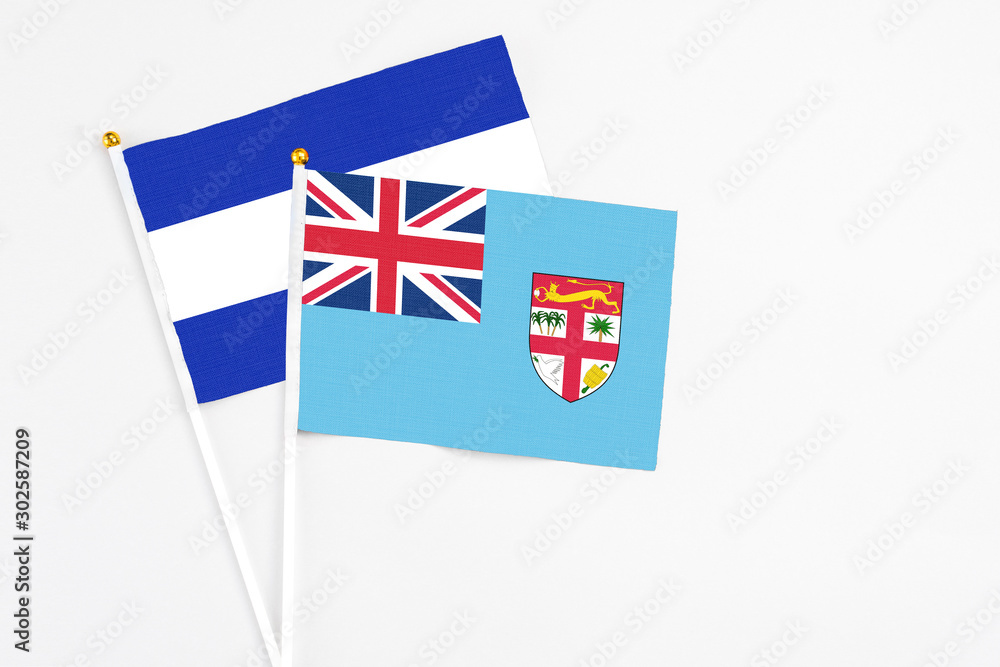 Fototapeta premium Fiji and El Salvador stick flags on white background. High quality fabric, miniature national flag. Peaceful global concept.White floor for copy space.
