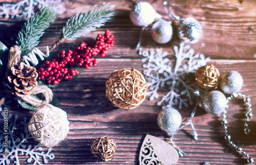 Christmas background of Christmas toys, spruce twigs, snowflakes, stars, rattan balls and tinsel on a wooden brown table