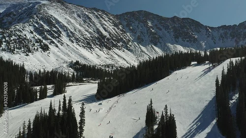 Panning right to left Aerial drone footage of skiers at Arapahoe basin in Summit County Colorado. photo