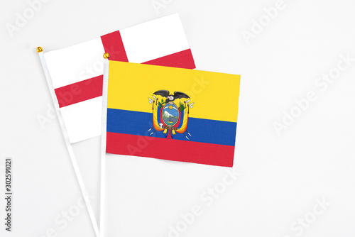 Ecuador and England stick flags on white background. High quality fabric, miniature national flag. Peaceful global concept.White floor for copy space.