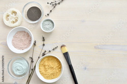 Cosmetic clay powder and facial mask composition on wooden background, natural skin care, copy space.