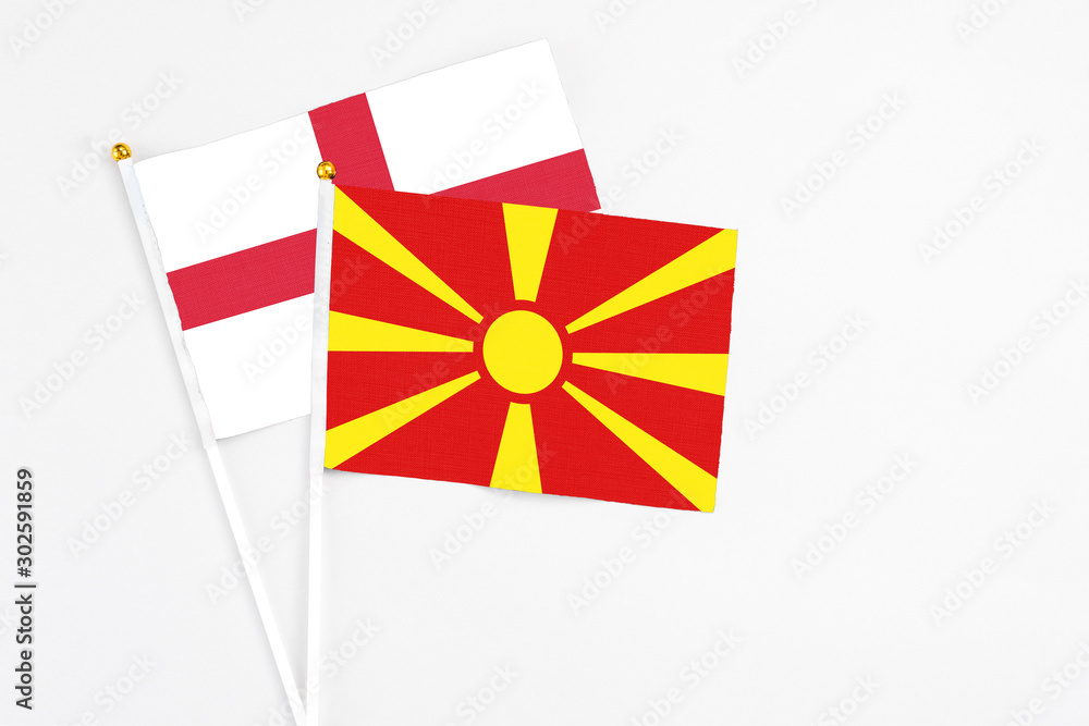 Macedonia and England stick flags on white background. High quality fabric, miniature national flag. Peaceful global concept.White floor for copy space.