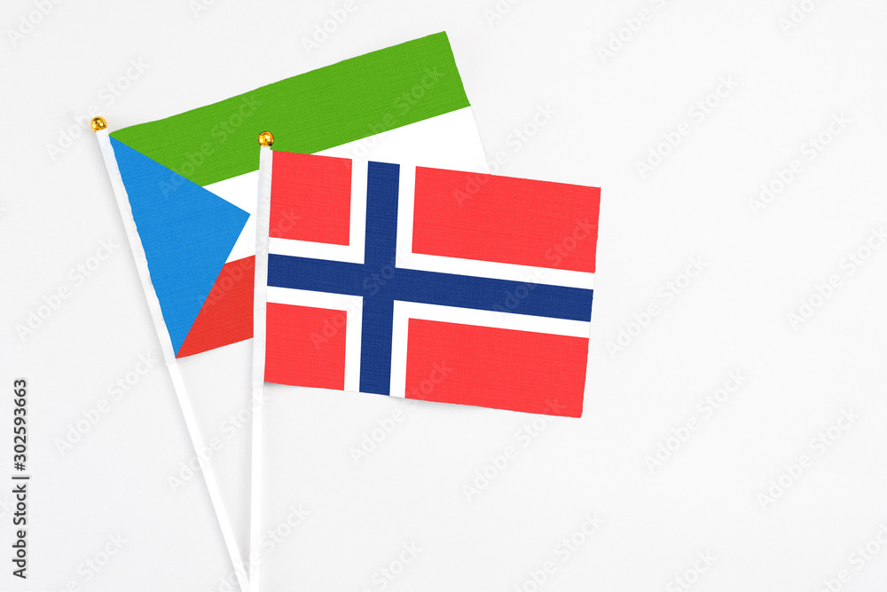 Bouvet Islands and Equatorial Guinea stick flags on white background. High quality fabric, miniature national flag. Peaceful global concept.White floor for copy space.