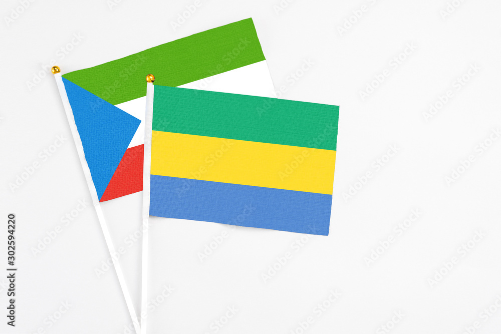 Gabon and Equatorial Guinea stick flags on white background. High quality fabric, miniature national flag. Peaceful global concept.White floor for copy space. Gabon and Equatorial Guinea stick flags on white background. High quality fabric, miniature national flag. Peaceful global concept.White floor for copy space.