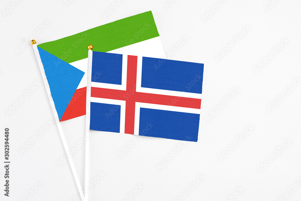 Iceland and Equatorial Guinea stick flags on white background. High quality fabric, miniature national flag. Peaceful global concept.White floor for copy space.