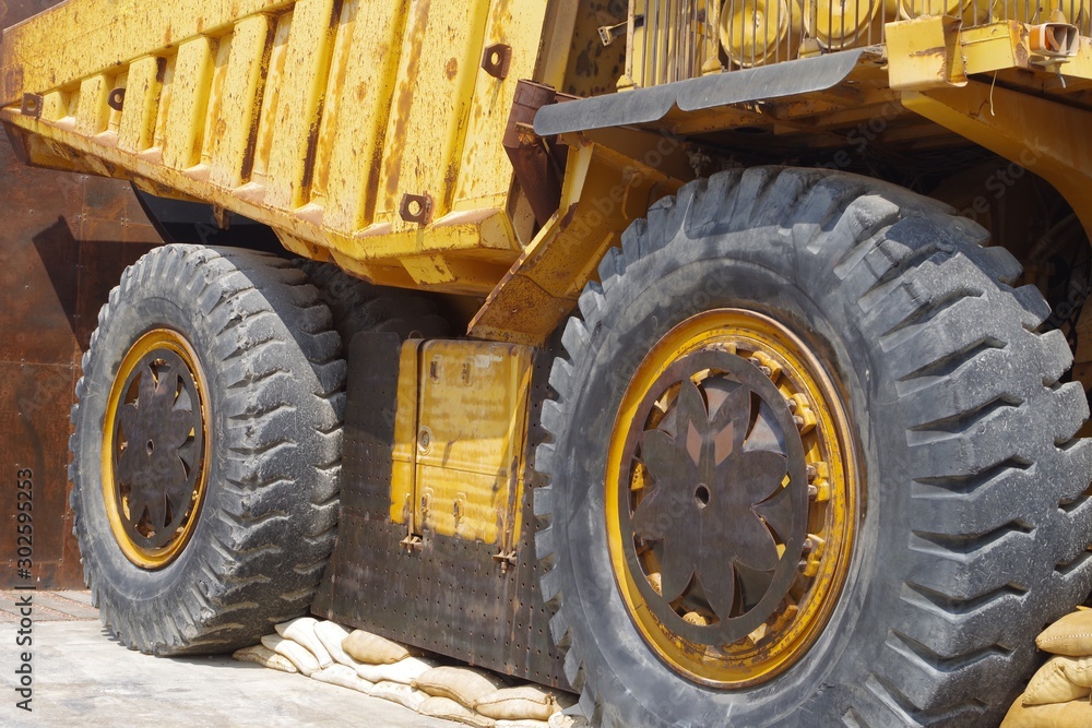 Close up picture of a big yellow mining truck.