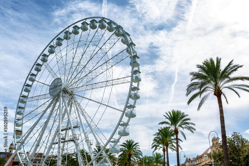 Genoa, Italy, 10/04/2019: Ferris wheel on the promenade in the beautiful port city against a bright cloudy sky. Close-up. Genoa, Italy, 10/04/2019: Ferris wheel on the promenade in the beautiful port city against a bright cloudy sky. Close-up.