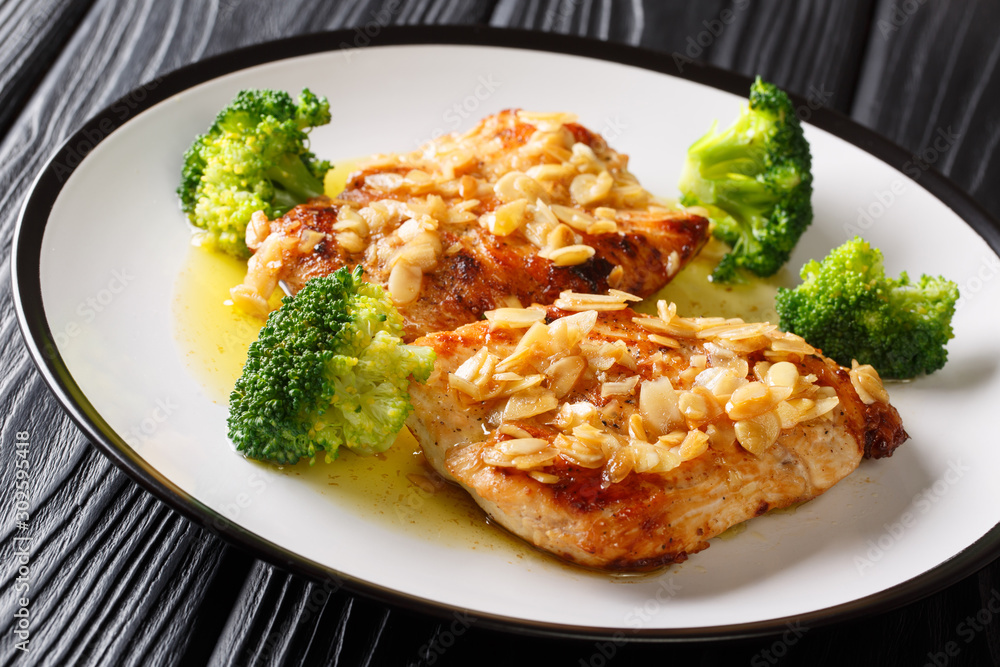 Festive fried chicken fillet with almonds served with broccoli close-up on a plate. horizontal Festive fried chicken fillet with almonds served with broccoli close-up on a plate. horizontal