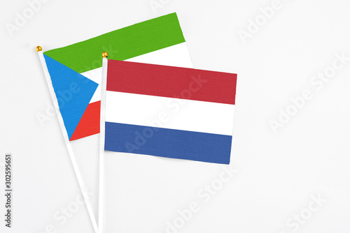 Free Download Netherlands and Equatorial Guinea stick flags on white background. High quality fabric, miniature national flag. Peaceful global concept.White floor for copy space. - GFXLoad