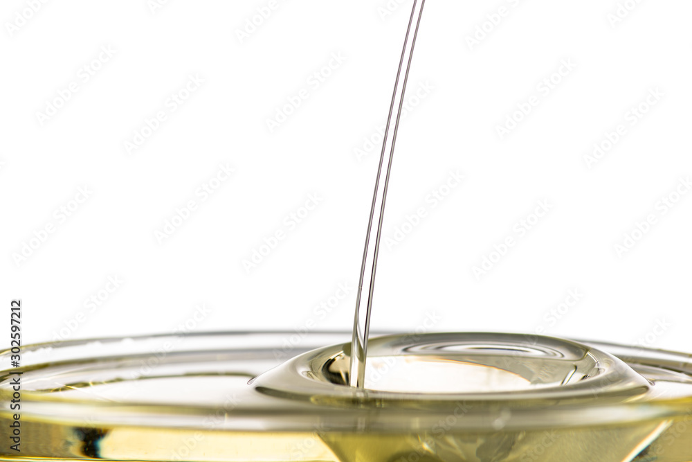 splash of yellow vegetable oil in a bowl on a white background splash of yellow vegetable oil in a bowl on a white background