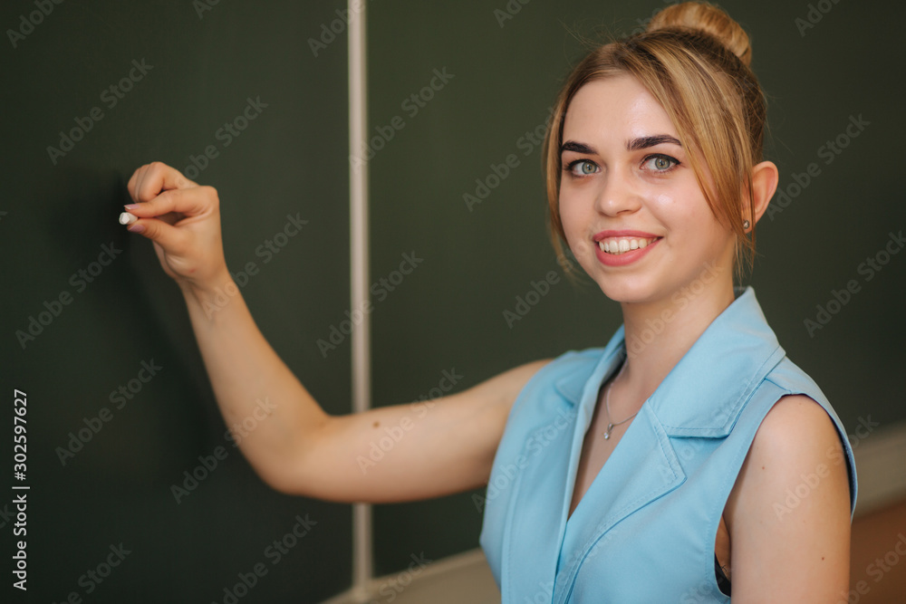 Female teacher whiting thomething on school desk. Young teacher Female teacher whiting thomething on school desk. Young teacher
