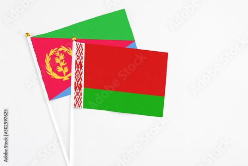 Belarus and Eritrea stick flags on white background. High quality fabric, miniature national flag. Peaceful global concept.White floor for copy space. photo