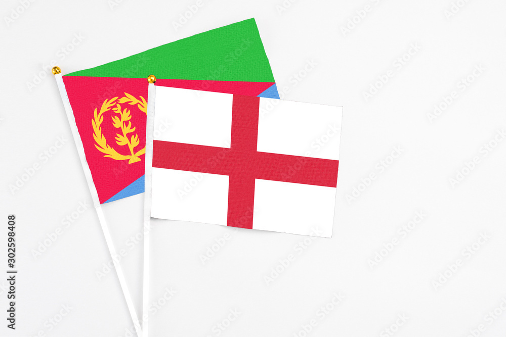 England and Eritrea stick flags on white background. High quality fabric, miniature national flag. Peaceful global concept.White floor for copy space.
