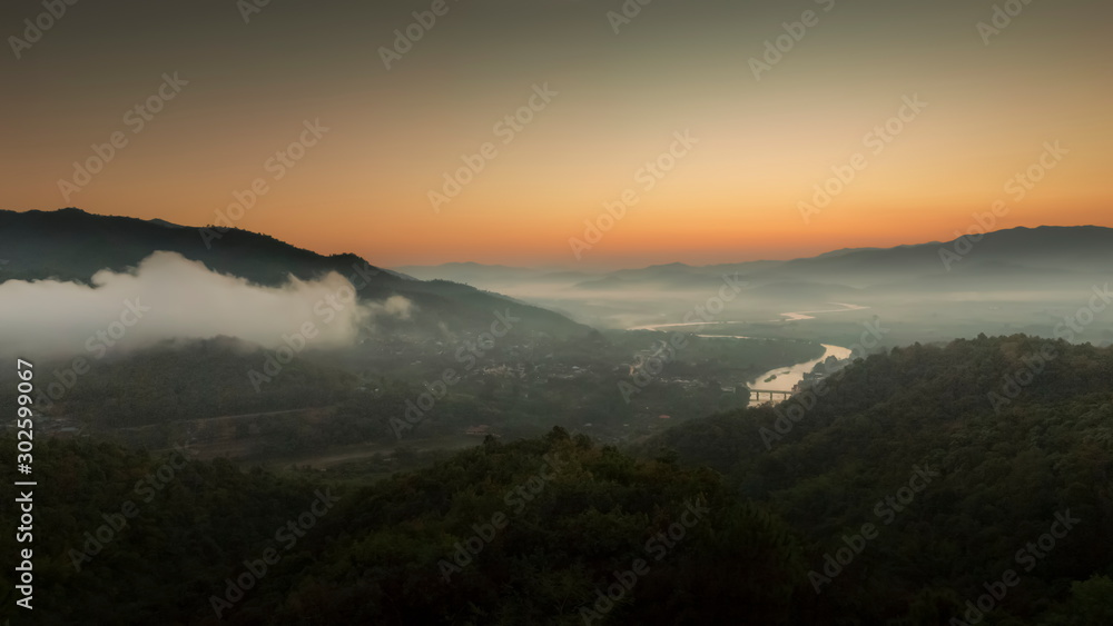 Mountain view panorama morning above Kok river around with sea of mist, mountain and yellow light in the sky background, sunrise at Wat Tha Ton, Tha Ton, Fang, Chiang Mai, Thailand.