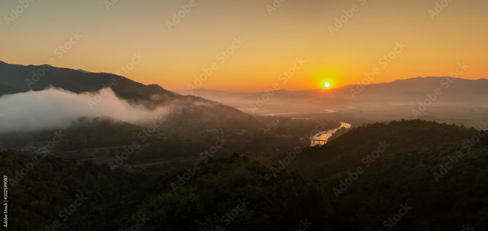 Mountain view panorama morning above Kok river around with sea of mist, mountain and yellow light in the sky background, sunrise at Wat Tha Ton, Tha Ton, Fang, Chiang Mai, Thailand.