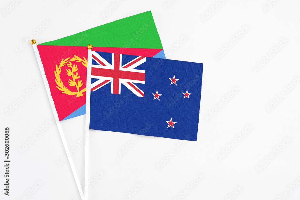 New Zealand and Eritrea stick flags on white background. High quality fabric, miniature national flag. Peaceful global concept.White floor for copy space. New Zealand and Eritrea stick flags on white background. High quality fabric, miniature national flag. Peaceful global concept.White floor for copy space.