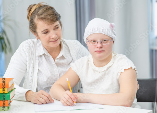 Portrait of a teacher and girl with Down Syndrome at school