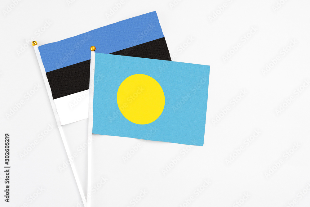 Palau and Estonia stick flags on white background. High quality fabric, miniature national flag. Peaceful global concept.White floor for copy space. Palau and Estonia stick flags on white background. High quality fabric, miniature national flag. Peaceful global concept.White floor for copy space.