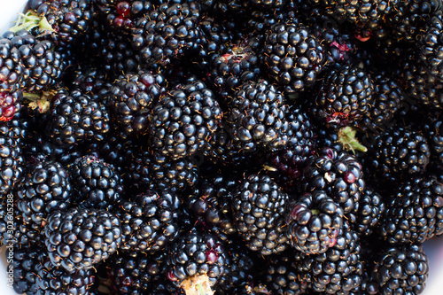 Fresh BlackBerry berry . ready for use. Pile of fresh blackberries on a black background. the view from the top. space for text. Dark blue BlackBerry. Background with blackberries.