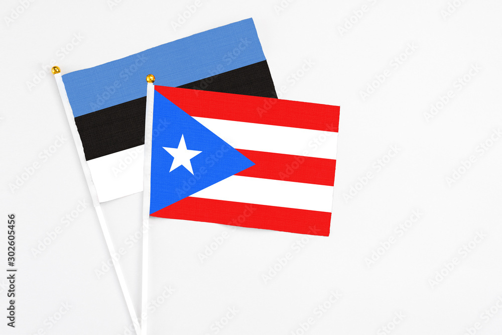 Puerto Rico and Estonia stick flags on white background. High quality fabric, miniature national flag. Peaceful global concept.White floor for copy space. Puerto Rico and Estonia stick flags on white background. High quality fabric, miniature national flag. Peaceful global concept.White floor for copy space.