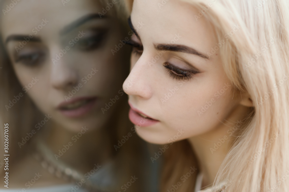 Portrait of a beautiful blonde girl. Reflection in the mirror. Portrait of a beautiful blonde girl. Reflection in the mirror.