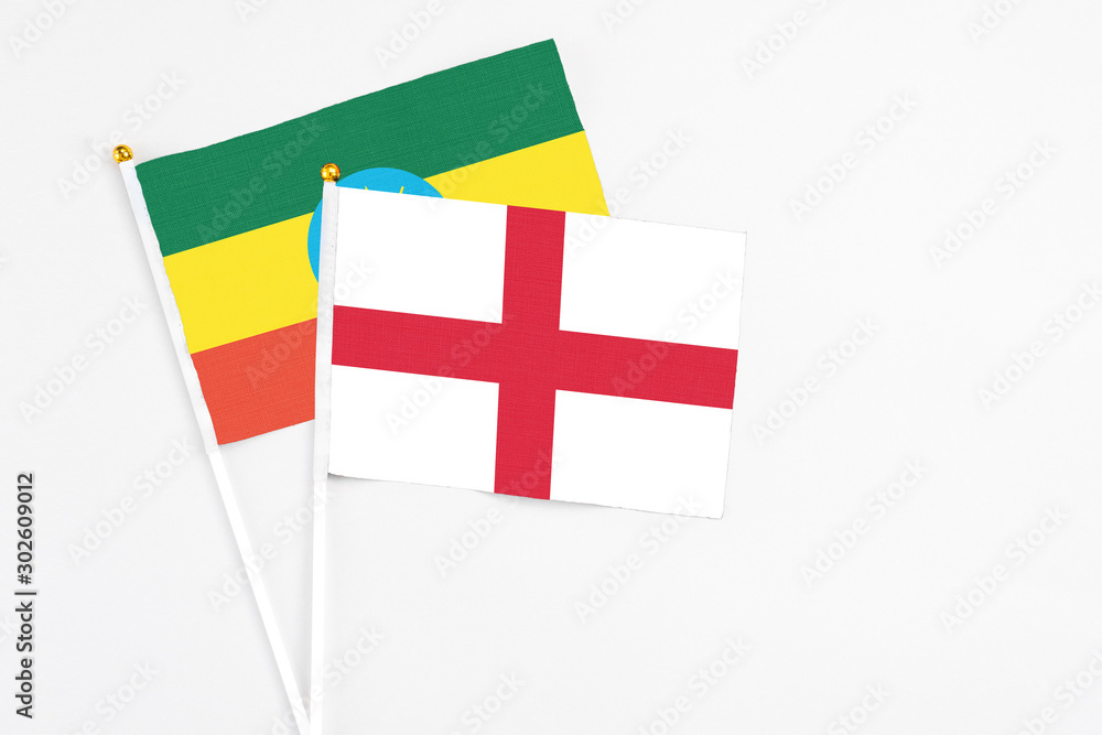 England and Ethiopia stick flags on white background. High quality fabric, miniature national flag. Peaceful global concept.White floor for copy space.