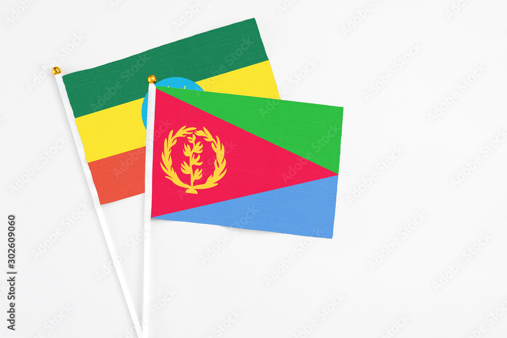 Eritrea and Ethiopia stick flags on white background. High quality fabric, miniature national flag. Peaceful global concept.White floor for copy space. Eritrea and Ethiopia stick flags on white background. High quality fabric, miniature national flag. Peaceful global concept.White floor for copy space.
