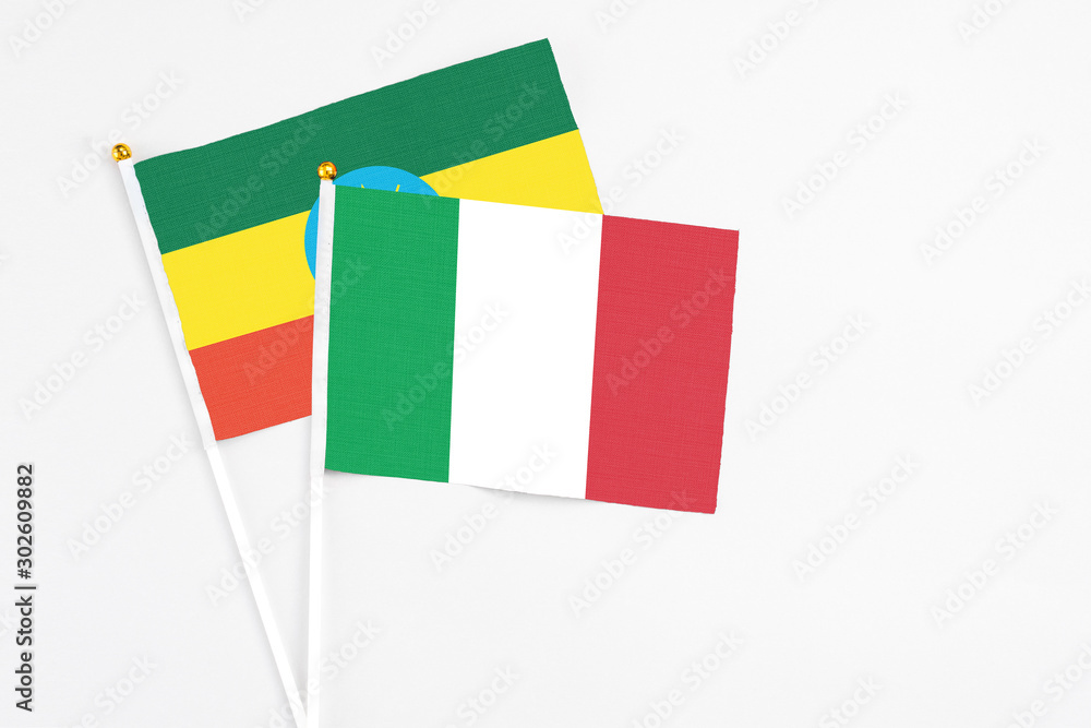 Italy and Ethiopia stick flags on white background. High quality fabric, miniature national flag. Peaceful global concept.White floor for copy space.