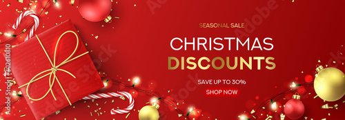 Christmas sale web banner template. Holiday background with red gift box, light garlands, Christmas golden balls, confetti and candy canes. Vector illustration. Happy New Year poster.