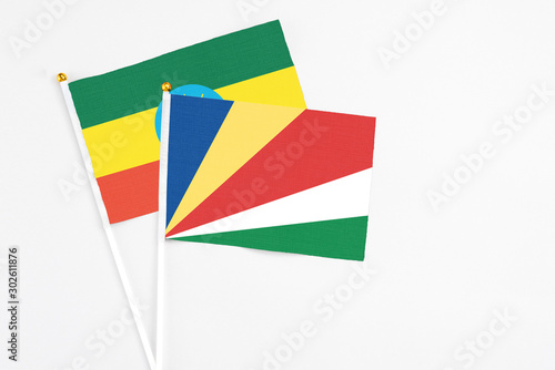 Free Download Seychelles and Ethiopia stick flags on white background. High quality fabric, miniature national flag. Peaceful global concept.White floor for copy space. - GFXLoad
