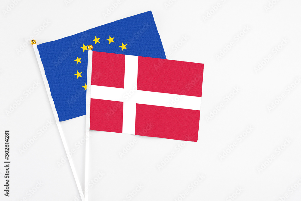 Denmark and European Union stick flags on white background. High quality fabric, miniature national flag. Peaceful global concept.White floor for copy space.