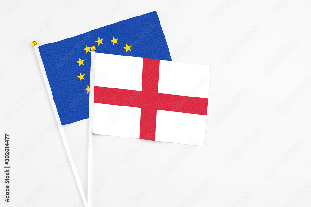 England and European Union stick flags on white background. High quality fabric, miniature national flag. Peaceful global concept.White floor for copy space.