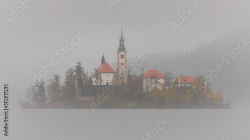 Island with church in Bled in the fog