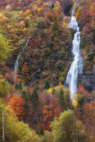 Waterfall in a colorful autumn forest in italy