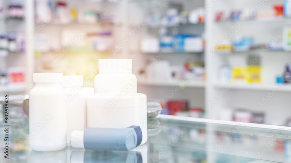 Bottle of medicine and medicine box in pharmacy drugstore and Pharmacy blurred with store drugs shelves interior background Bottle of medicine and medicine box in pharmacy drugstore and Pharmacy blurred with store drugs shelves interior background