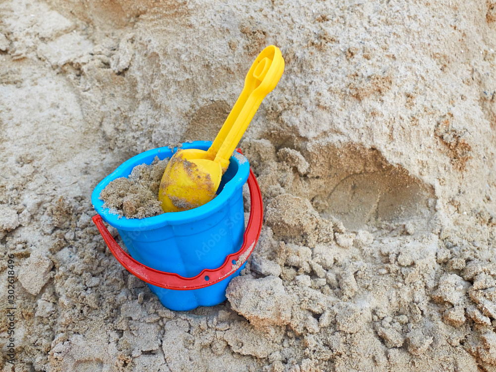 Yellow scoop and blue bucket in the sandbox. Photo of children sandbox Yellow scoop and blue bucket in the sandbox. Photo of children sandbox