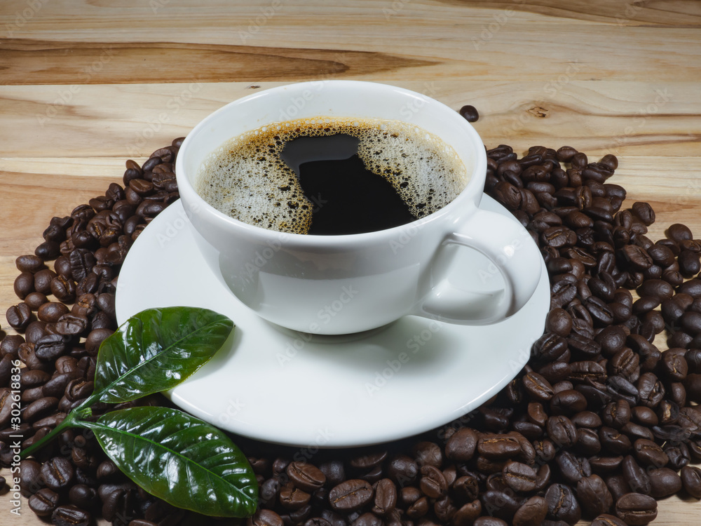 Obraz premium Coffee cup coffee beans coffee leaf on the table