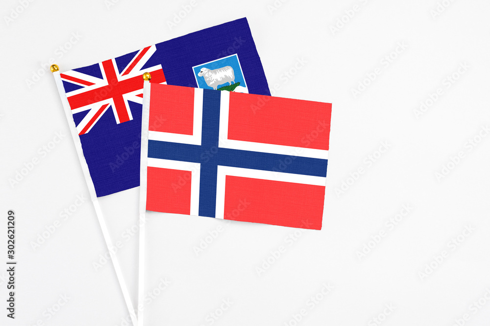 Bouvet Islands and Falkland Islands stick flags on white background. High quality fabric, miniature national flag. Peaceful global concept.White floor for copy space. Bouvet Islands and Falkland Islands stick flags on white background. High quality fabric, miniature national flag. Peaceful global concept.White floor for copy space.