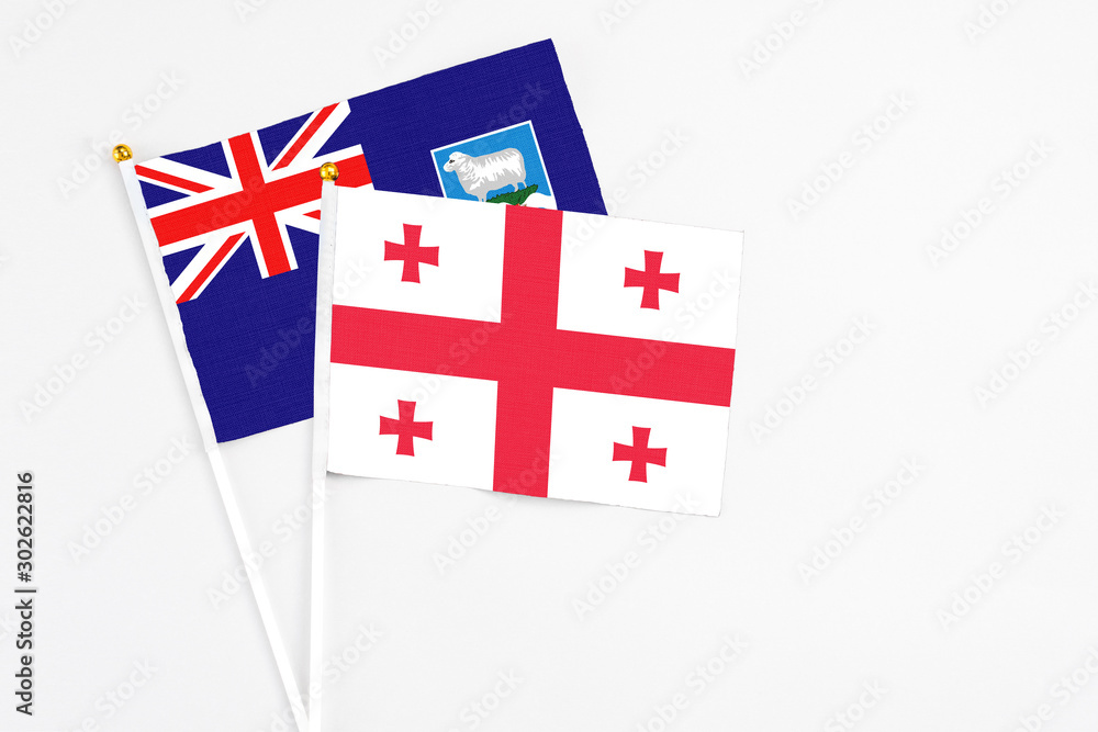 Georgia and Falkland Islands stick flags on white background. High quality fabric, miniature national flag. Peaceful global concept.White floor for copy space.