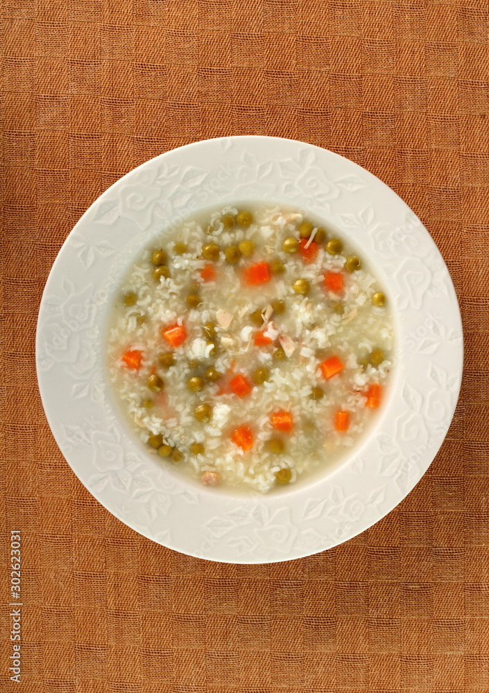 Rice soup with chicken, green peas and carrots. Directly Above. Rice soup with chicken, green peas and carrots. Directly Above.
