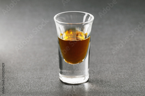 Shot with whiskey on a dark background, close-up