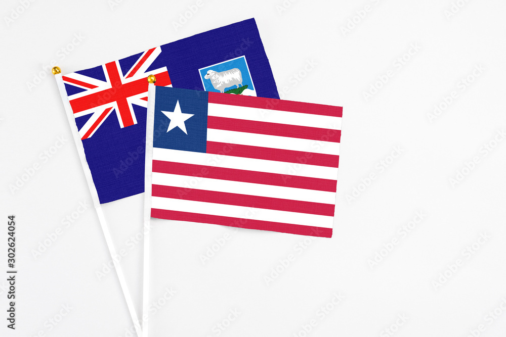 Liberia and Falkland Islands stick flags on white background. High quality fabric, miniature national flag. Peaceful global concept.White floor for copy space. Liberia and Falkland Islands stick flags on white background. High quality fabric, miniature national flag. Peaceful global concept.White floor for copy space.