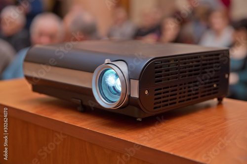 LCD video projector at business conference or lecture in office with copy space. projector on ceiling indoors.