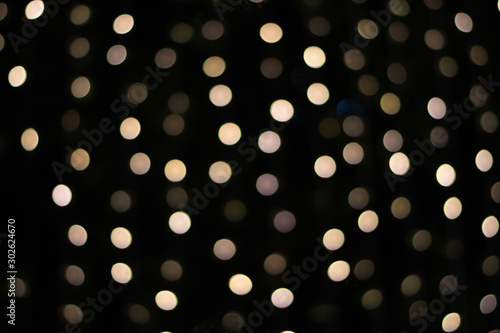 Golden bokeh on a black background, blurred lights