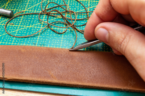 beveling cutting edge on the brown leather stripe for belt with special tool photo