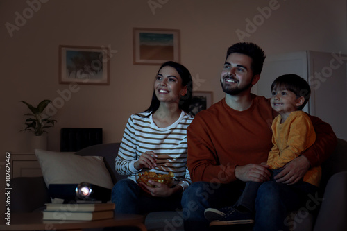 Family watching movie using video projector at home